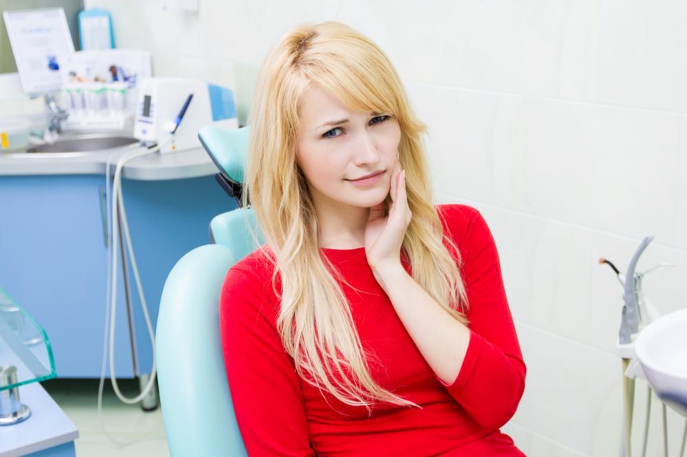 woman holding jaw from tooth pain during dental emergency