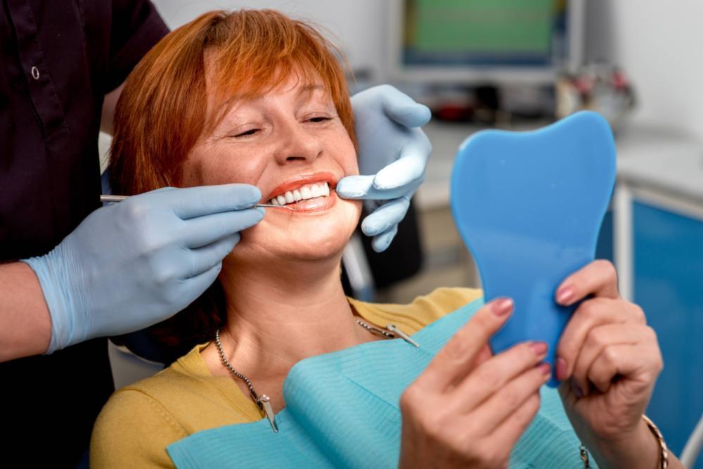 a woman smiles in the dental office | dental implants colorado springs