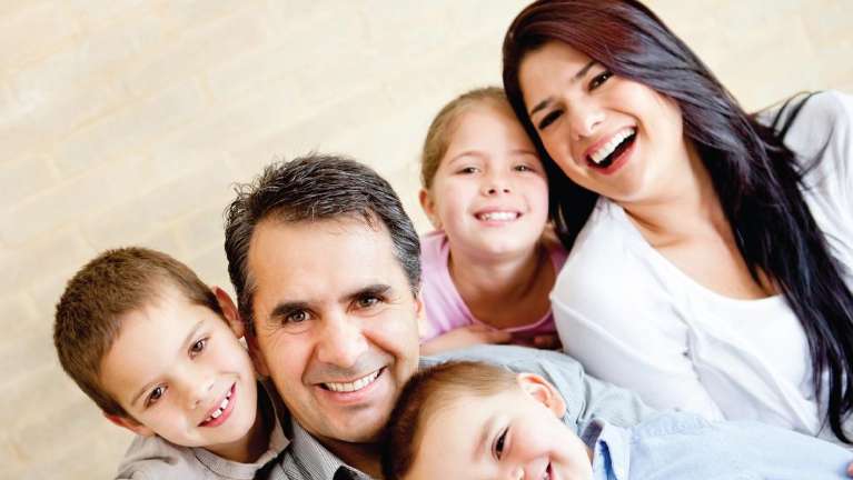 Family of five smiling after dental visit to Springs Family Dental