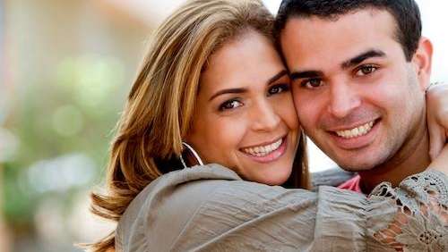 Couple smiling after porcelain veneers from Springs Family Dental