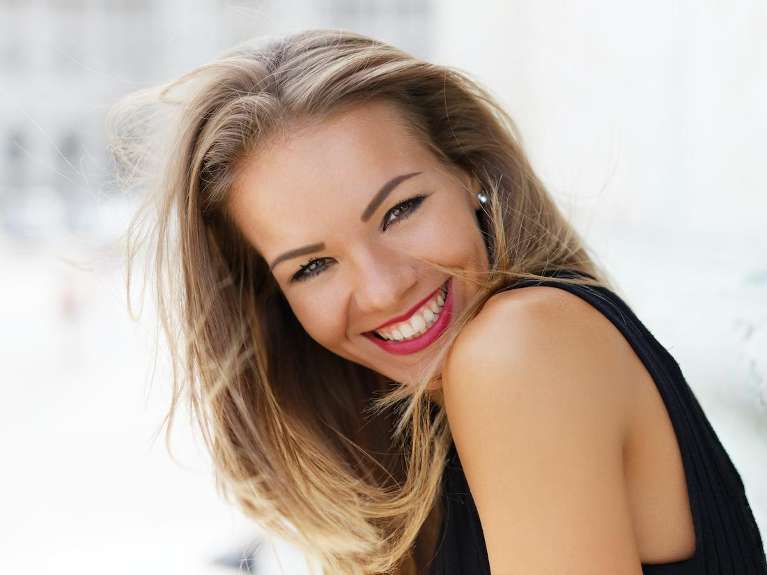 A lady smiling after teeth whitening in Colorado Springs, CO